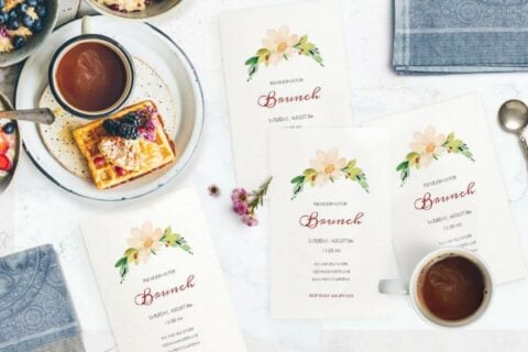 Inspiring Brunch Party Invitation Display: Invitations neatly arranged on a table with a crisp white cloth, positioned alongside charming tea cups.