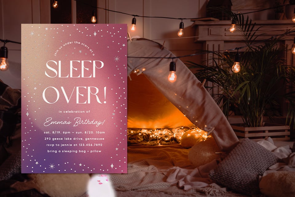 1-girl-birthday-sleepover-tent-invite Sleepover birthday invitation displayed in a cozy indoor tent setup with pillows, blankets, and warm string lights, creating a dreamy, starry-night atmosphere for a girls’ sleepover party.