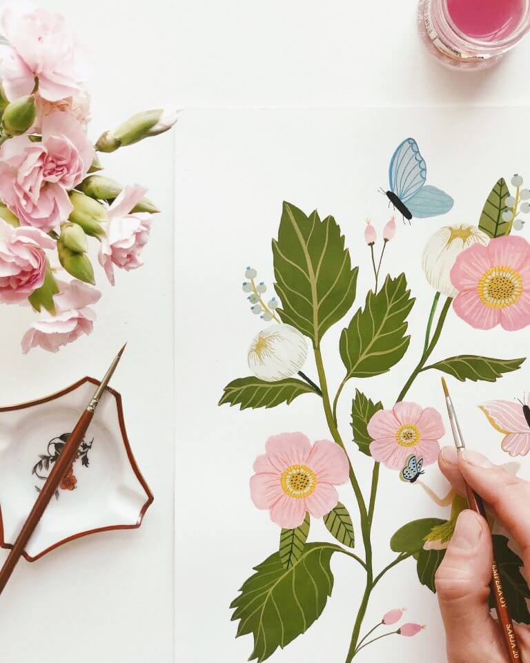 Artist Lisa Mönttinen meticulously brings her designs to life with a watercolor brush, her strokes capturing the fluid beauty of her artistic vision.