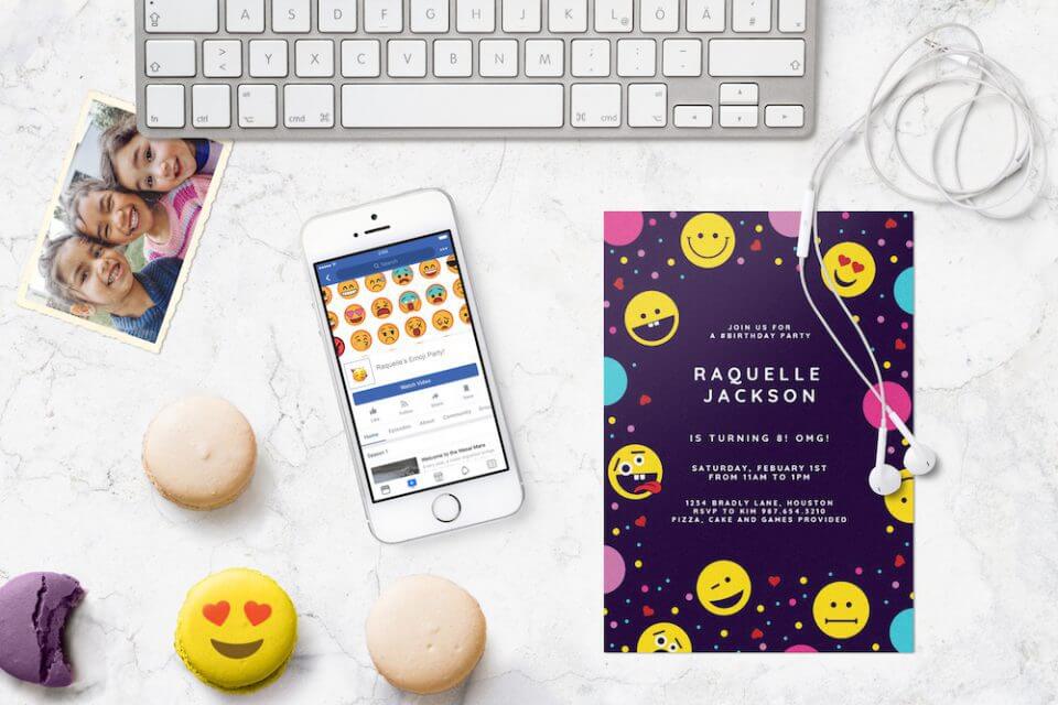 Vibrant emoji-themed birthday party invitation set against a lively purple background. Various emoji illustrations are arranged on a sleek marble surface near a keyboard, accompanied by two delectable macarons.