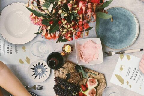 Bouquet of Fresh Flowers as a Dinner Party Centerpiece, Complemented by a Beautifully Set Table, Decor, Charcuterie Board, and Beer Selection