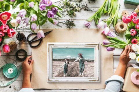 A framed photograph surrounded by a bouquet of flowers, possibly representing one of the 'Mother's Day Activity and Gift Ideas'.