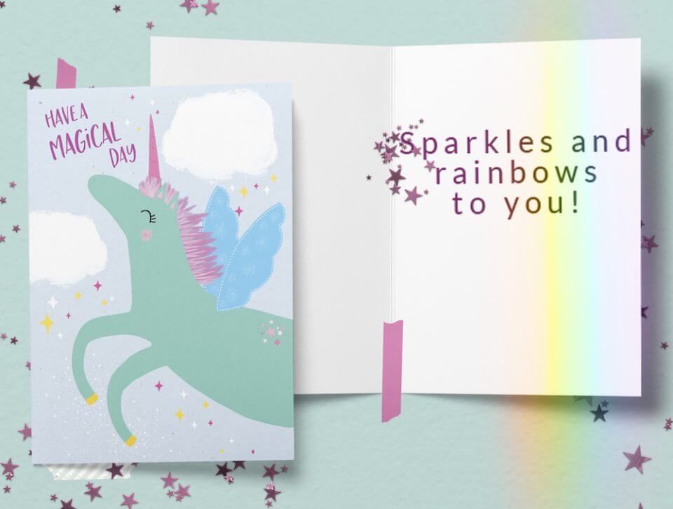 Enchanting Unicorn and Rainbows Birthday Card: 'Have a Magical Day' in Pink, Featuring a Whimsical Green Unicorn with a Pink Horn and Blue Wings. Set on a Light Green Surface, Spreading Joy and Wonder for All.