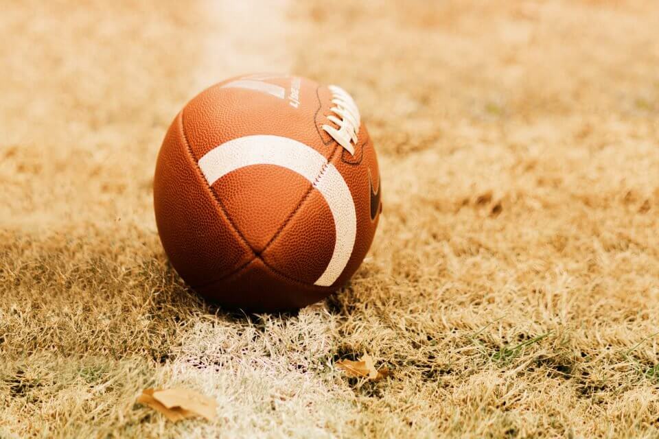 Football placed on yellow grass, suggesting a fun Friendsgiving activity to enjoy together.