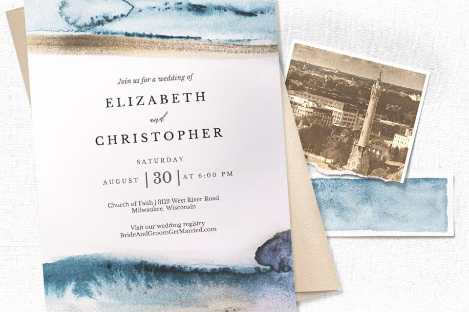 Modern Fluid Wedding Invite: Sea wave illustration, centered black text. Rests on white surface beside a cream envelope and an old photograph.