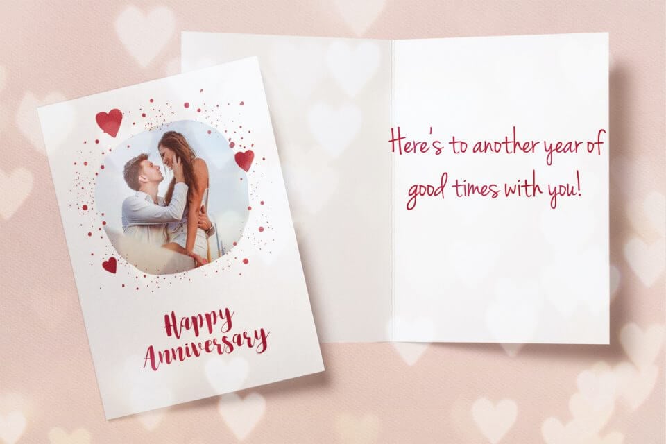 Expressive Happy Anniversary wishes in red and white on a charming photo card, adorned with whimsical hearts to convey love and celebration.