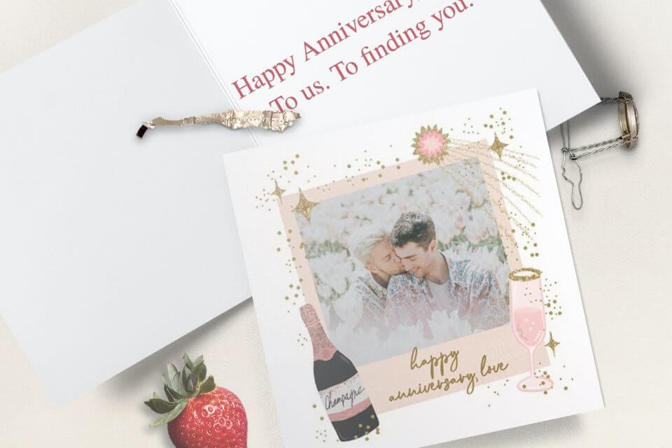 Send heartfelt wishes for a Happy Anniversary through an exquisite photo card featuring elegant gold champagne and delicate pink script, capturing the essence of joy and celebration.