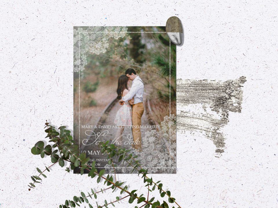 Lace-Inspired Photography Invitation with White Text, Resting on Concrete Surface Beside Fresh Green Plant Branches.