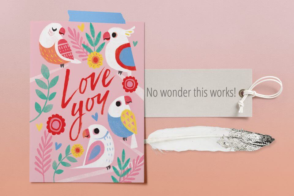 Too Tweet Love Card: Pastel Bird Illustrations in Various Soft Hues, Surrounded by Delicate Flowers. The words 'Love You' Stand out in Bright Red at the Center. Positioned Near a Bird Feather and a Tag with a Thoughtful Note.