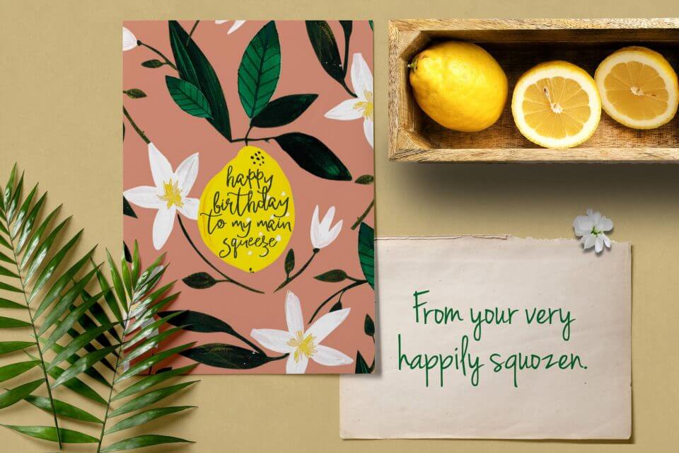 Artistic Birthday Card: Watercolor Flowers Surround a Lemon, 'Happy Birthday to my Main Squeeze.' Nearby, Fresh Lemons, a Note, and Botanical Touches.