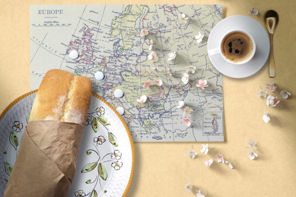 Travel-themed anniversary: Floral plate with bread, espresso, and a Europe map. A unique way to celebrate love and wanderlust!"