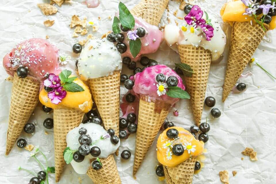 Indulge in the sweet extravagance of an Ice Cream Sundae Bar, where delectable ice creams are meticulously placed on kitchen paper, adorned with a delightful array of edible flowers and plump blueberries.