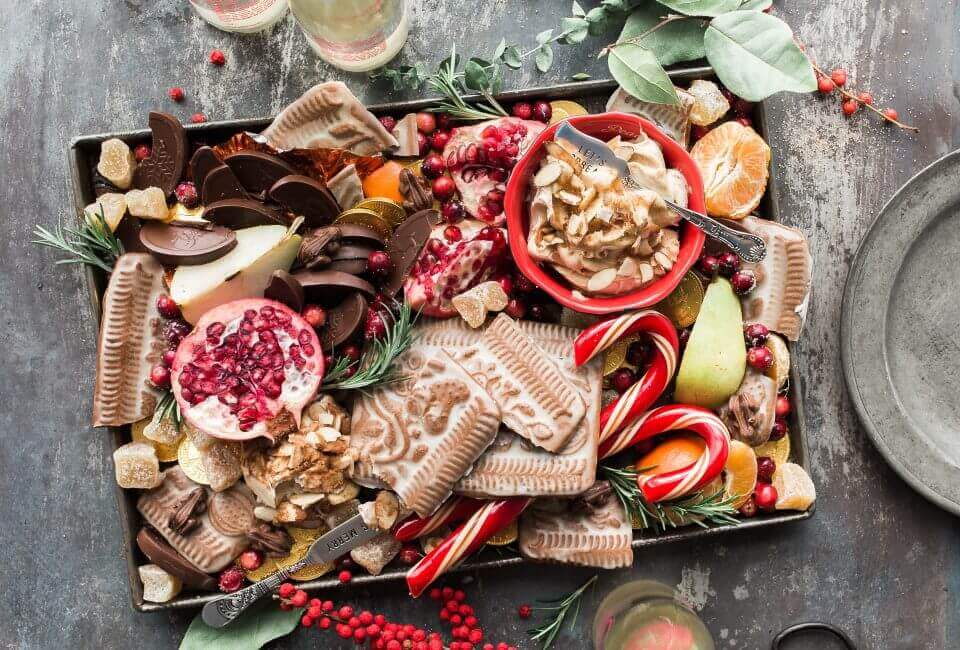 A beautifully arranged charcuterie board with an assortment of fruits, spreads, cookies, and Christmas candy canes, elevating the holiday party to the next level - 10 Christmas Decor Ideas to Wow Your Guests.