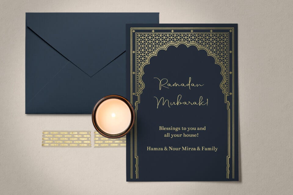 Elegant Ramadan Greetings: "Gateway" Ramadan Card, featuring a luxurious gold ornamental line design against a dark background. Positioned alongside a softly lit candle and a sleek black envelope, creating a sophisticated and serene ambiance.