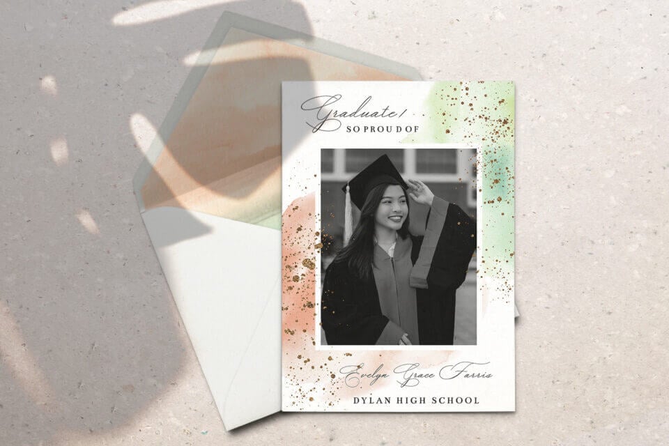 A Green and Pink Glitter Graduation Announcement card and its matching envelope, featuring a photograph of a woman elegantly dressed in graduation attire.