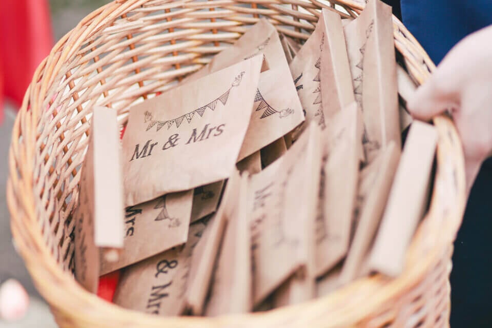 Bridal shower favor: Envelopes adorned with 'Mr & Mrs' carried in a charming basket.