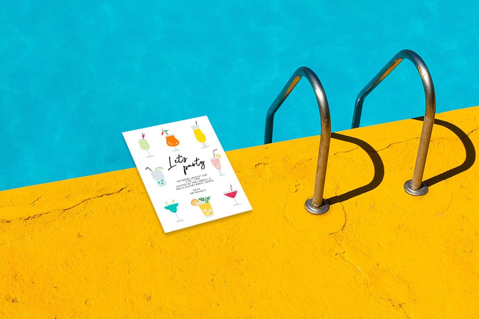 Let's Party Invitation: Vibrant cocktail illustrations adorn the scene of a poolside celebration, set against the backdrop of a sunny yellow concrete poolside. The invitation is perched elegantly at the pool's edge, ready to dive into the fun!