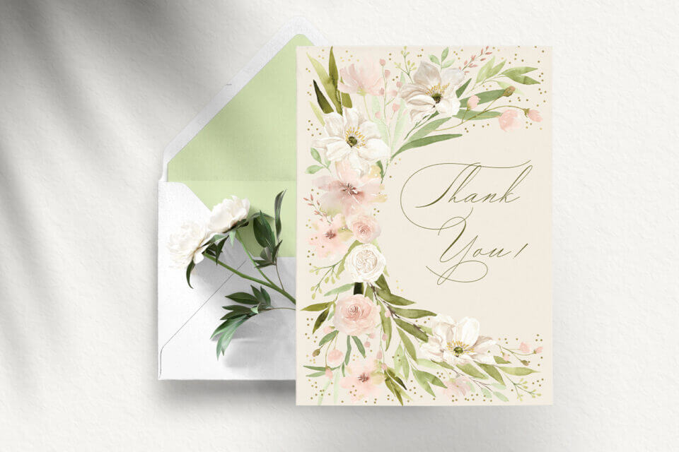 Wedding thank you card featuring pastel pink and green floral roses, adorned with elegant design and font. Set against an envelope and a blooming flower background for added charm.