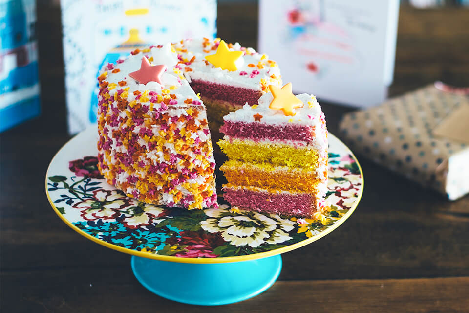 Gender-Neutral Baby Shower Themes: A Vibrant Cake Extravaganza in Yellow, Orange, and Pink with Starry Sprinkles.