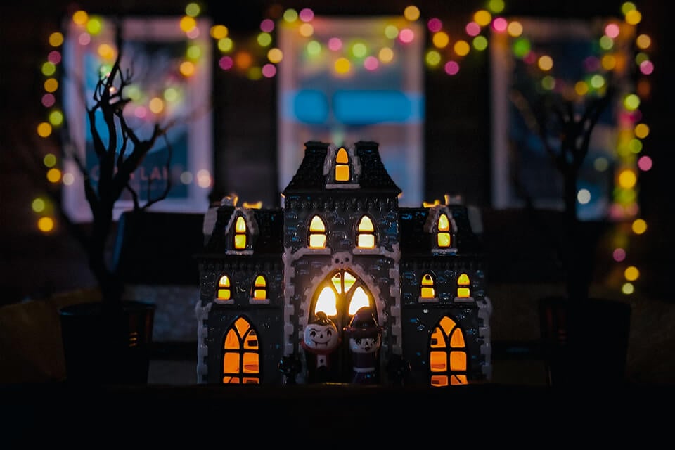 Eerie Haunted House: Dark, Creepy Decor Ideas for a Fun Halloween Party. A Small House with Glowing Windows Sets the Mood for Spooky Inspiration.