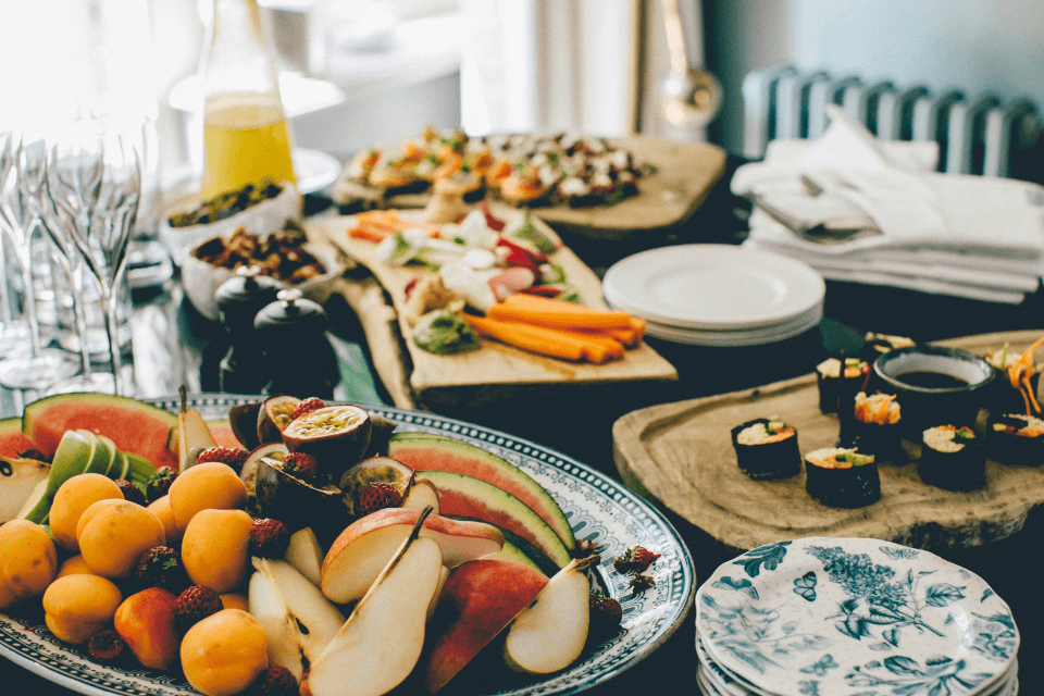 A table setting at a baptism and christening party, arrayed with an assortment of elegant finger foods, inviting guests to partake in a feast of celebration.