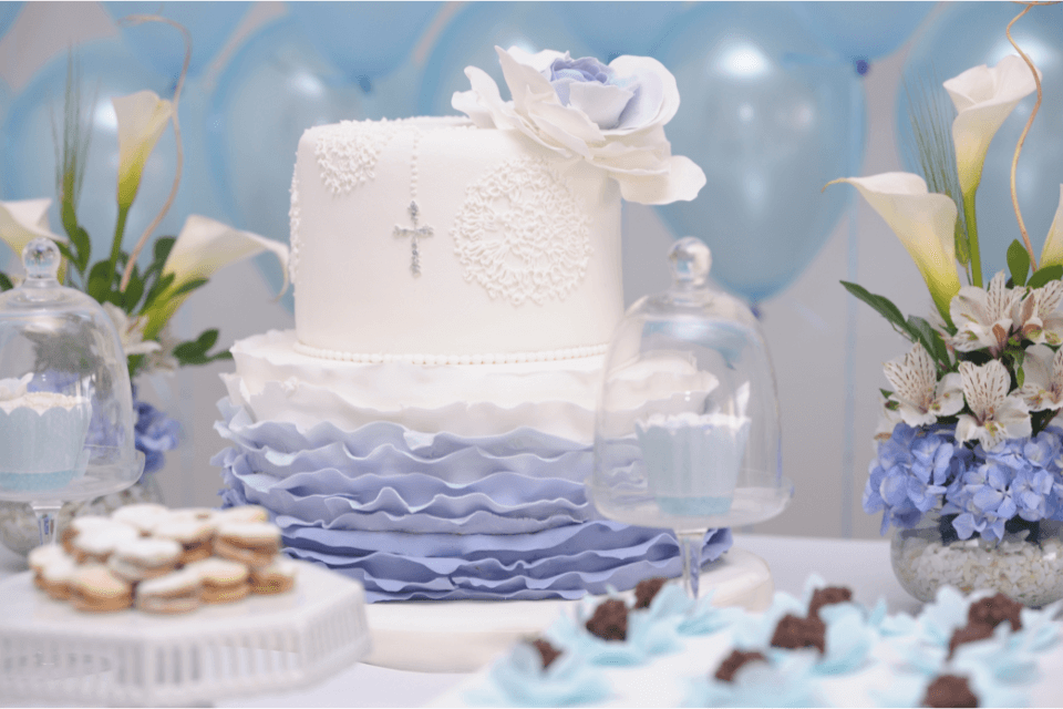 Elegant christening table decor in shades of purple, featuring a beautifully crafted cake, delicate cookies, and blooms, creating a picture-perfect celebration.