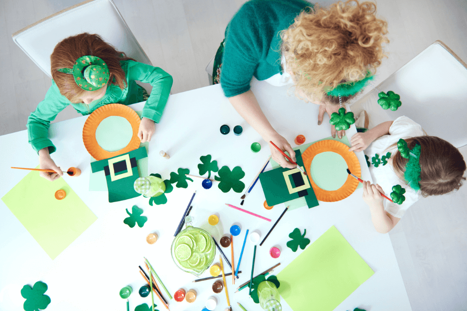 a woman with two small girls making st patrick's decorations and crafts
