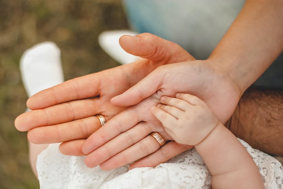 Baptism Party Ideas: Celebrate Your Little One with Love - Featuring a Tender Image of Baby Hands Cradled in Parents' Hands
