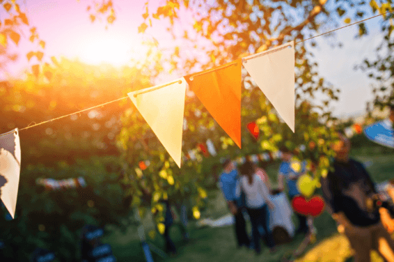 A colorful garland captured outdoors during a sunny day, set up for a graduation party. The garland, consisting of vibrant, festive colors, adds a cheerful and celebratory ambiance to the outdoor setting, perfectly complementing the joyous occasion of a graduation event.