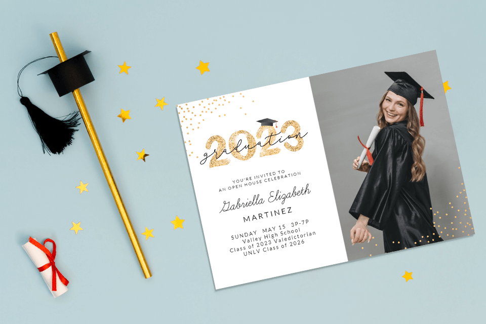 Graduation Invitation placed on a light blue background with a paper scroll and graduation cap straw near by