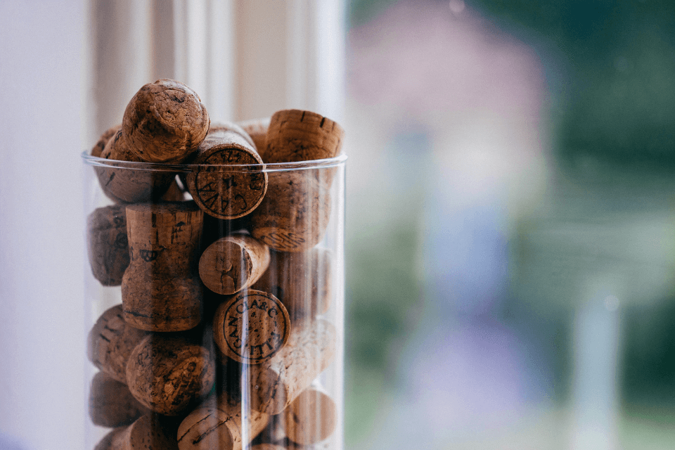 Wine corks collected in a clear glass container, showcasing a mosaic of winemaking memories and tastings enjoyed.
