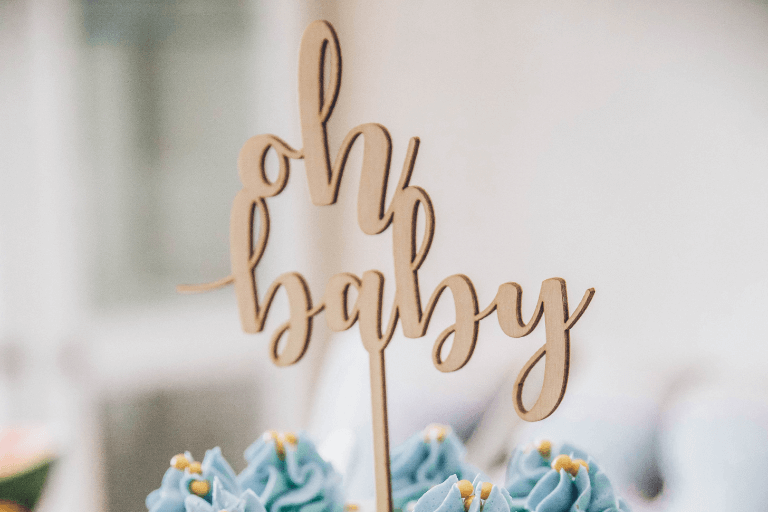 Charming 'Oh Baby' cake topper gracing a delightful baby shower, serving as the cover image for our comprehensive baby shower planning blog post.
