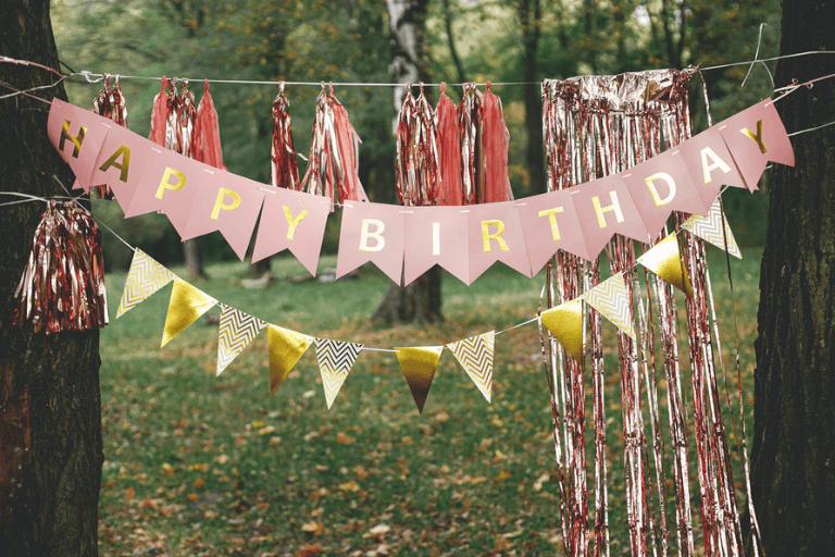 Vibrant Pink and gold Birthday Party Banner amidst Outdoor Celebration: Creative Teen Birthday party Decor Ideas