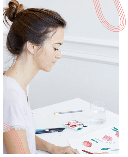 Portrait of Ashley DeMeyere, the talented greetings island designer, immersed in her creative studio, skillfully crafting a portrait adorned with her signature design elements.