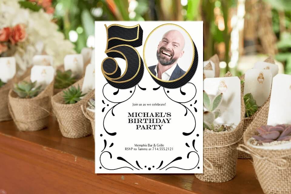 A 50th birthday party invitation featuring the number 50, with a photograph inside the zero. The invitation is elegantly placed on top of background of succulent plants as party favors