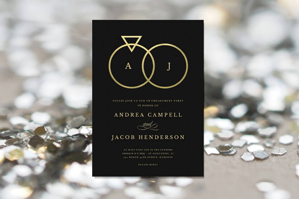 Sophisticated engagement party invitation featuring a striking black background adorned with a golden rings illustration at its center, symbolizing the union of two hearts