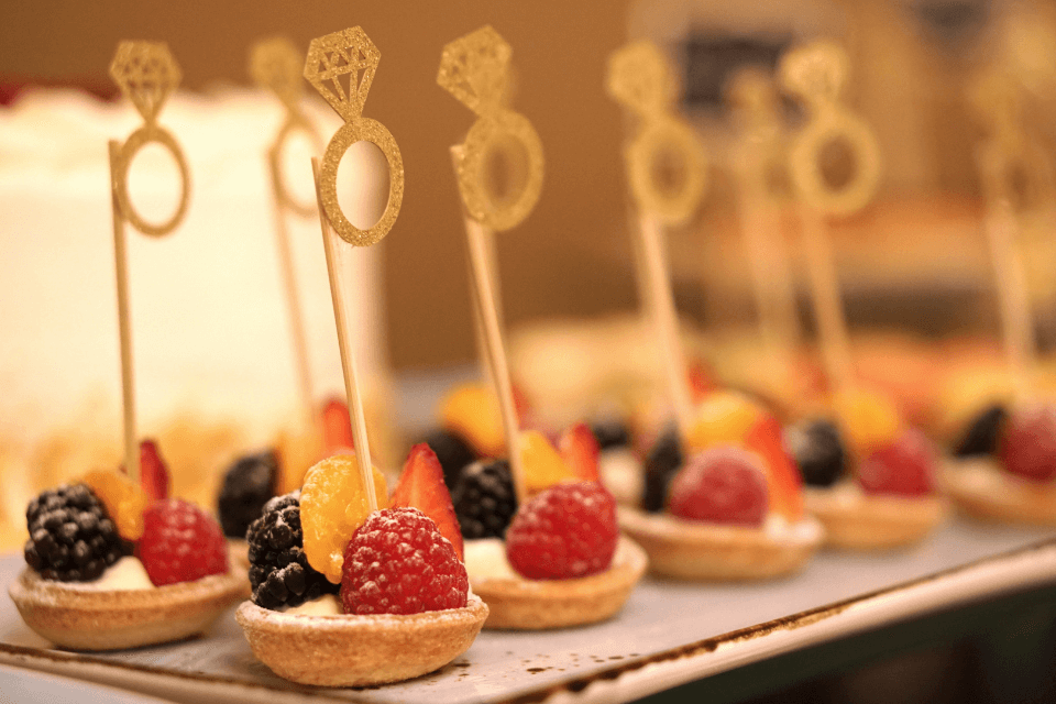 Indulge in petite fruit tarts adorned with delicate engagement ring decorations – the perfect bite-sized appetizers for a delightful bridal shower celebration
