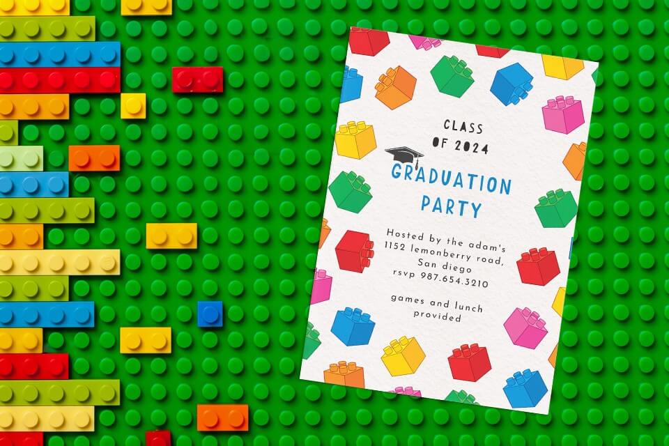 A charming preschool graduation party invitation adorned with colorful drawings reminiscent of kids' building blocks. The invitation rests atop a Lego surface