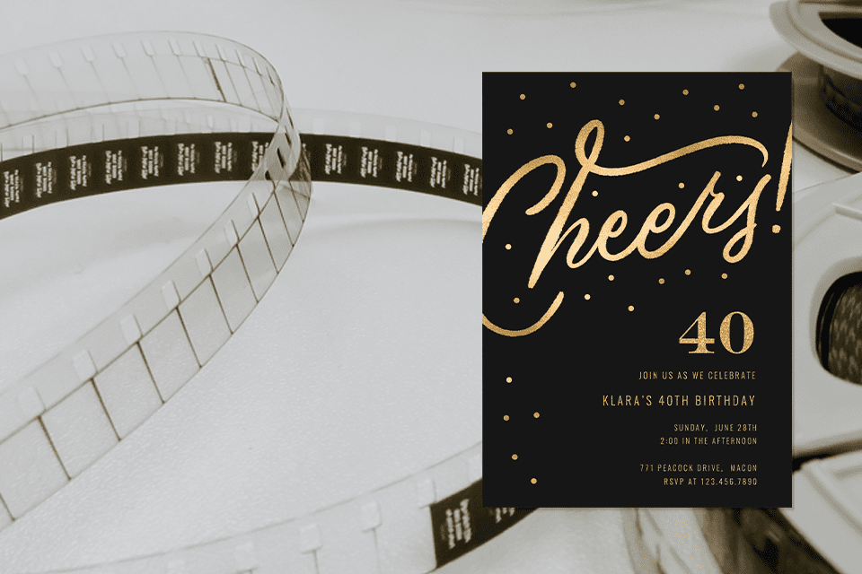 new-movie-theme-birthday-party-40th-invite-(1) Black and gold 40th birthday invitation with the word ‘Cheers!’ in large gold script and scattered gold dots, placed against a background featuring a close-up of film strips and movie reels.