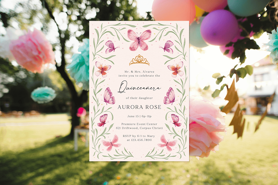 quinceañera-butterfly-invite-garden-outdoor-decor (1) Quinceañera invitation with a soft floral design featuring pink butterflies and green vines, displayed outdoors with pastel balloons and paper decorations hanging from trees in the background.