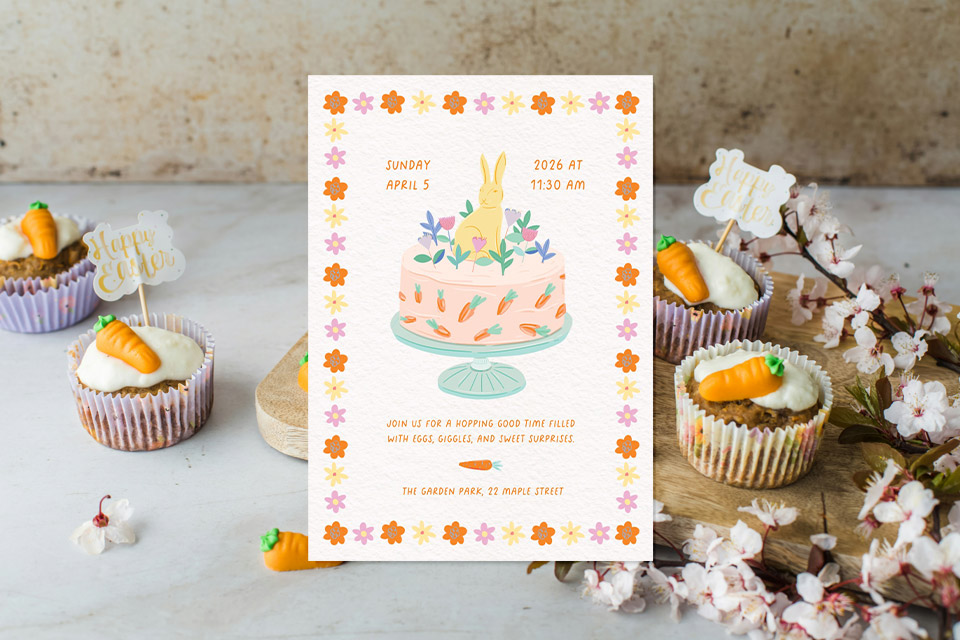 easter-carrot-invite Easter party invitation with a pastel cake and bunny illustration framed by floral details, placed among carrot-topped cupcakes and spring blossoms.