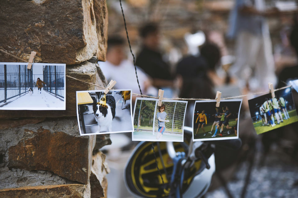 photos-memories-graduation-party String of small printed photos clipped to a line, displaying personal memories and moments at a graduation celebration.